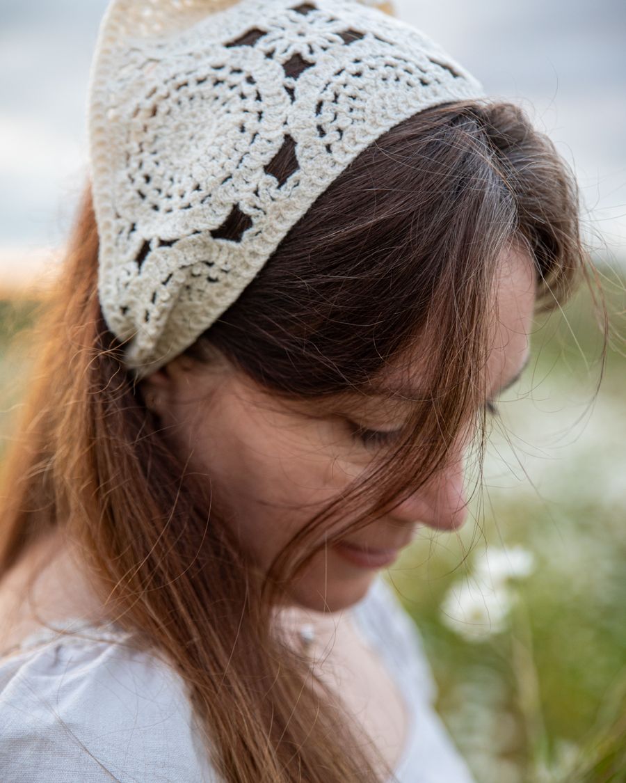 A woman wearing a wide oatmeal-colored crochet headband